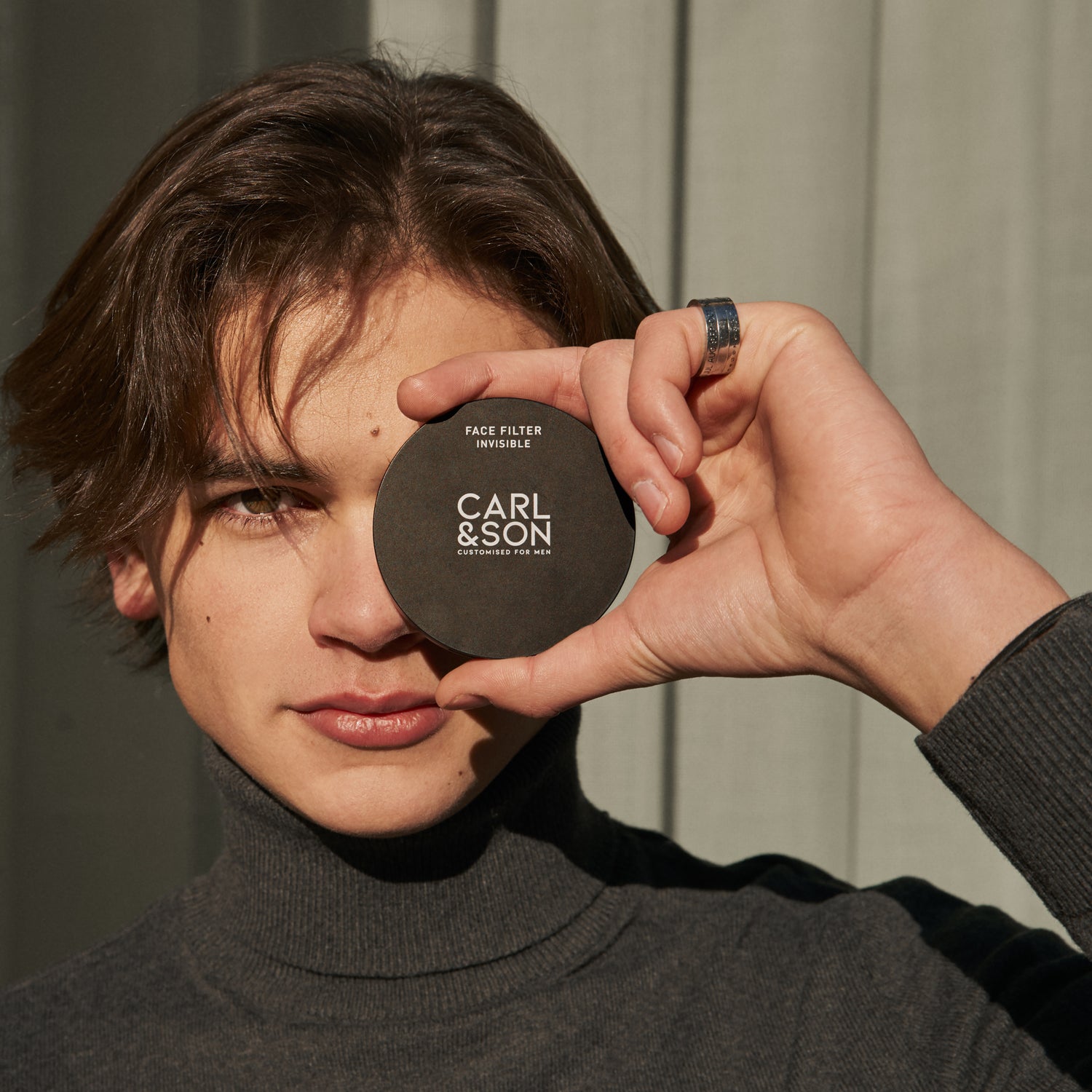 man holding face filter invisible in front of one eye